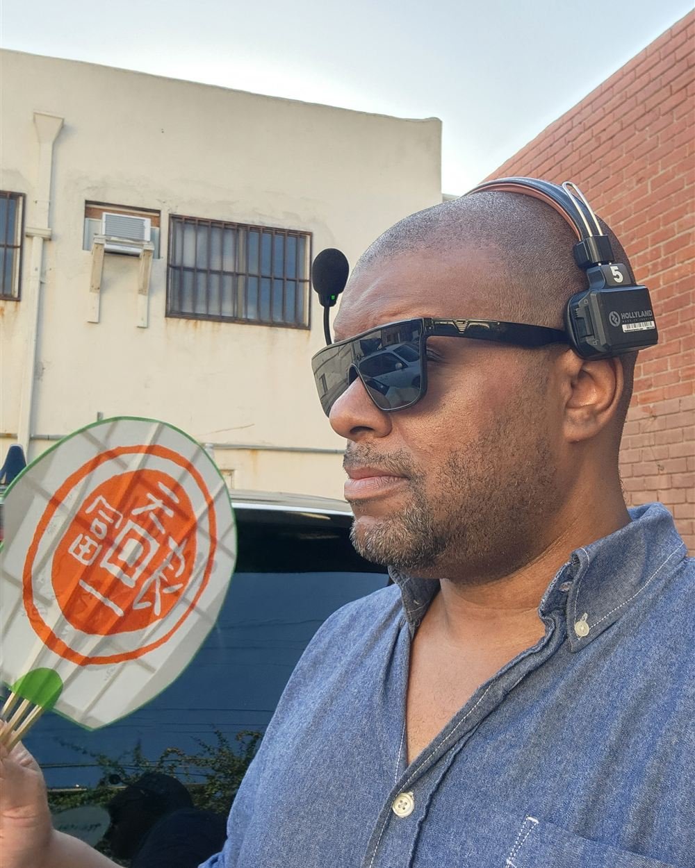Tommy on set in Los Angeles wearing a crew comms headset, during the BE:FIRST music video shoot